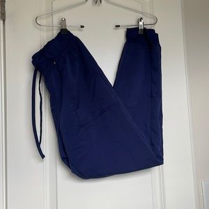 Small, dark blue scrub pants with 5 pockets/cuffed ankles and drawstring tie.